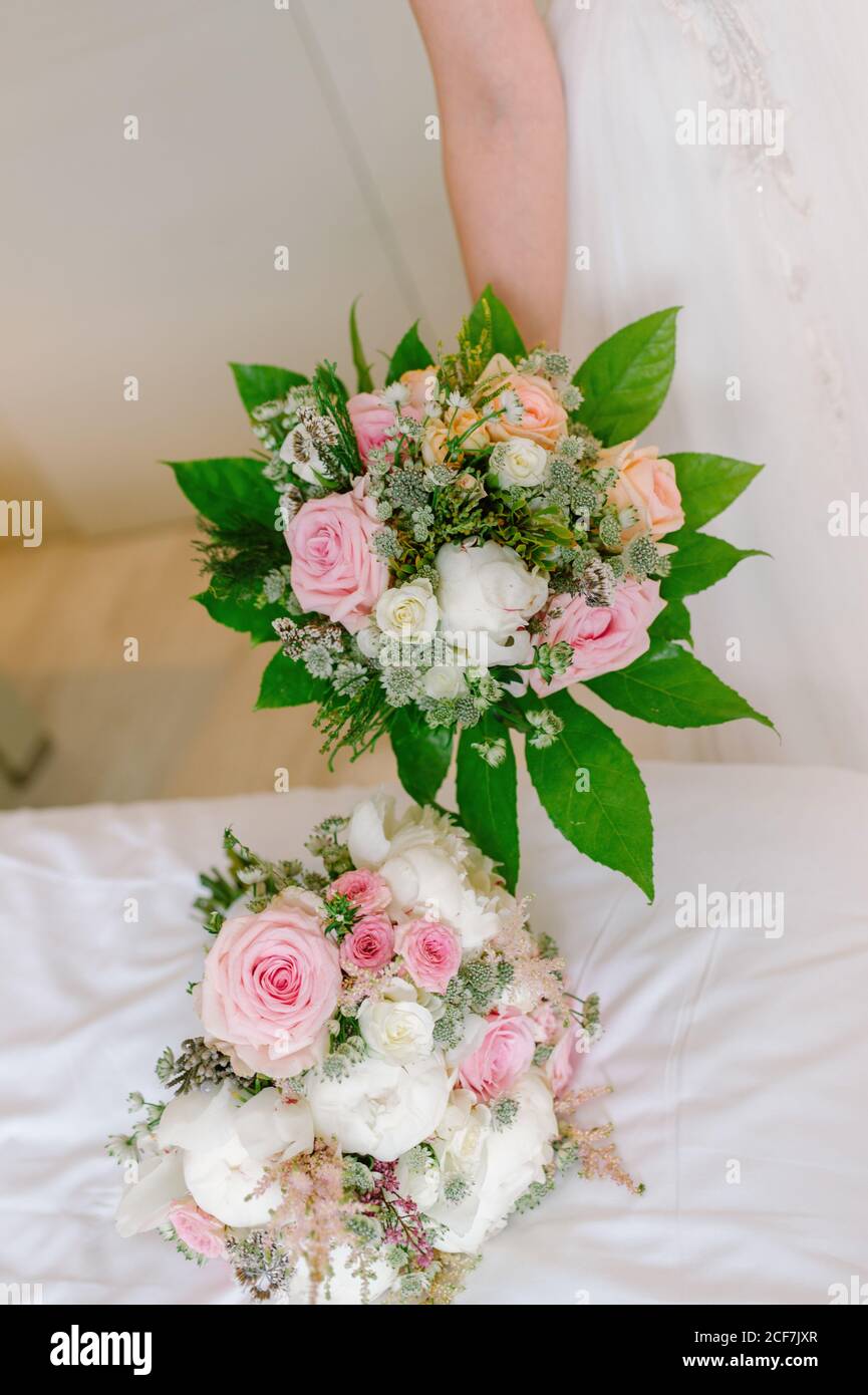 Crop sposa in abito bianco con delicato bouquet Foto Stock
