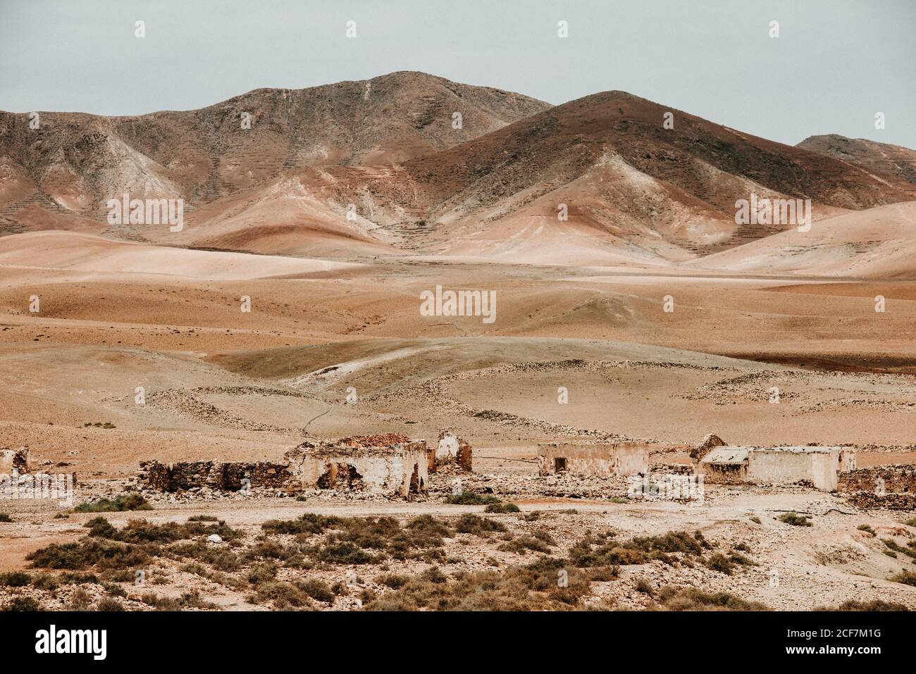 Vecchi edifici dilapidati nel deserto di montagna sotto il cielo nuvoloso Foto Stock