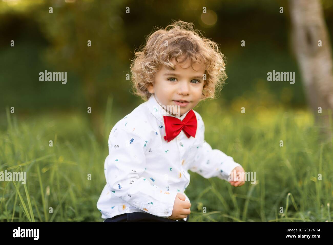 Un bambino di sesso maschile molto felice di divertirsi nel parco verde Foto Stock