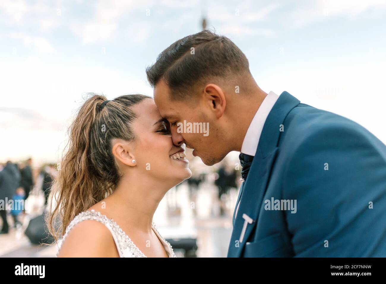 Sposo in abito da sposa blu in abito da sposa bianco Baciando con passione con la Torre Eiffel sullo sfondo a Parigi Foto Stock