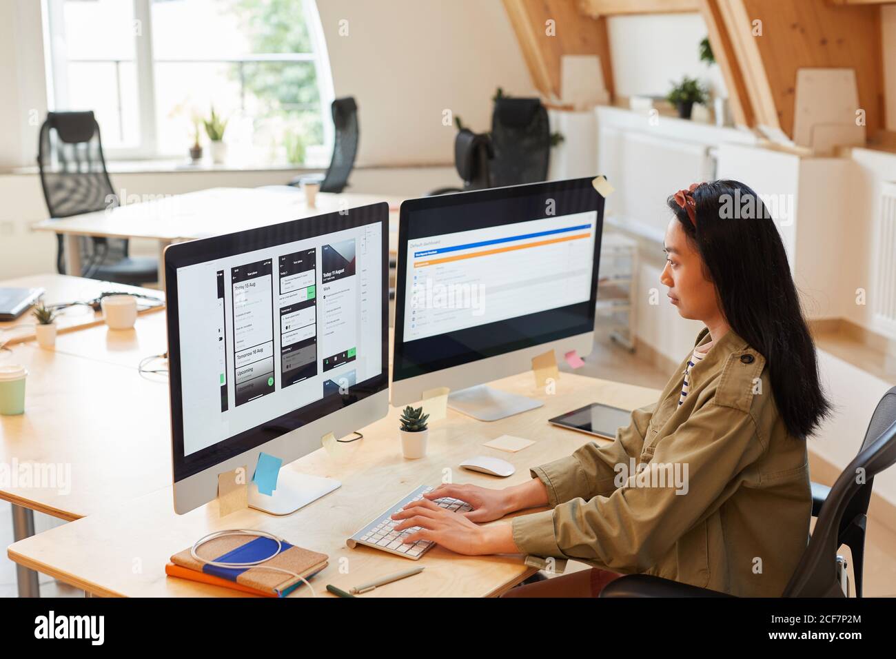 Giovane donna asiatica seduto al tavolo che scrive sul computer tastiera verifica il nuovo software in ufficio Foto Stock