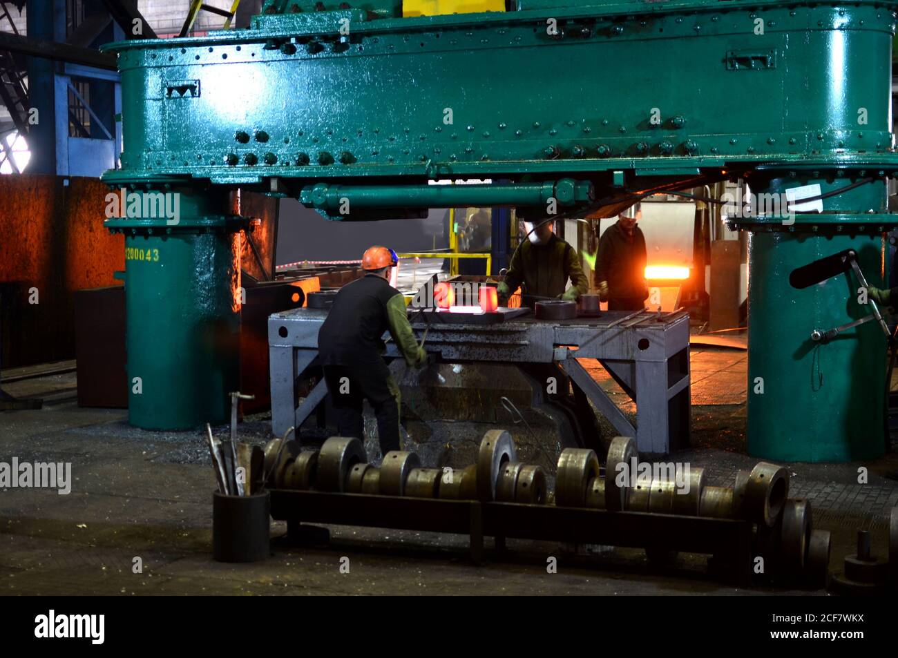 Processi di fabbro red ferro caldo sotto un enorme premere. Fucinato metallico, stampaggio sotto un martello forge in officina di forge foctory. Blacksmithing, meta Foto Stock