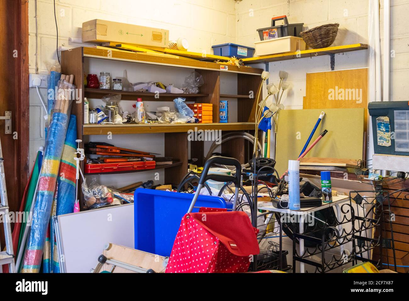 Spazio di deposito occupato in un garage, pieno di spazzatura disordinata e disordinata da accatestare per diversi anni. Disordine in garage. Foto Stock