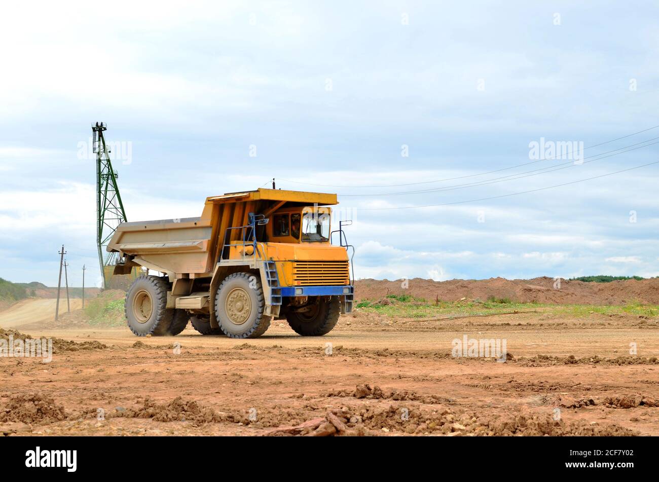 Grande dumper da miniera giallo che lavora in una buca di pietra calcarea. Carico e trasporto di minerali nella cava di dolomite. Bielorussia, Vitebsk, in Foto Stock