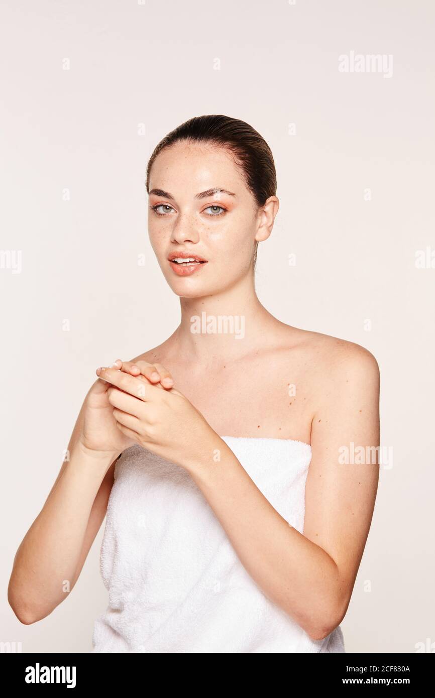 Donna felicissima che applica crema di recupero sulle mani Foto Stock