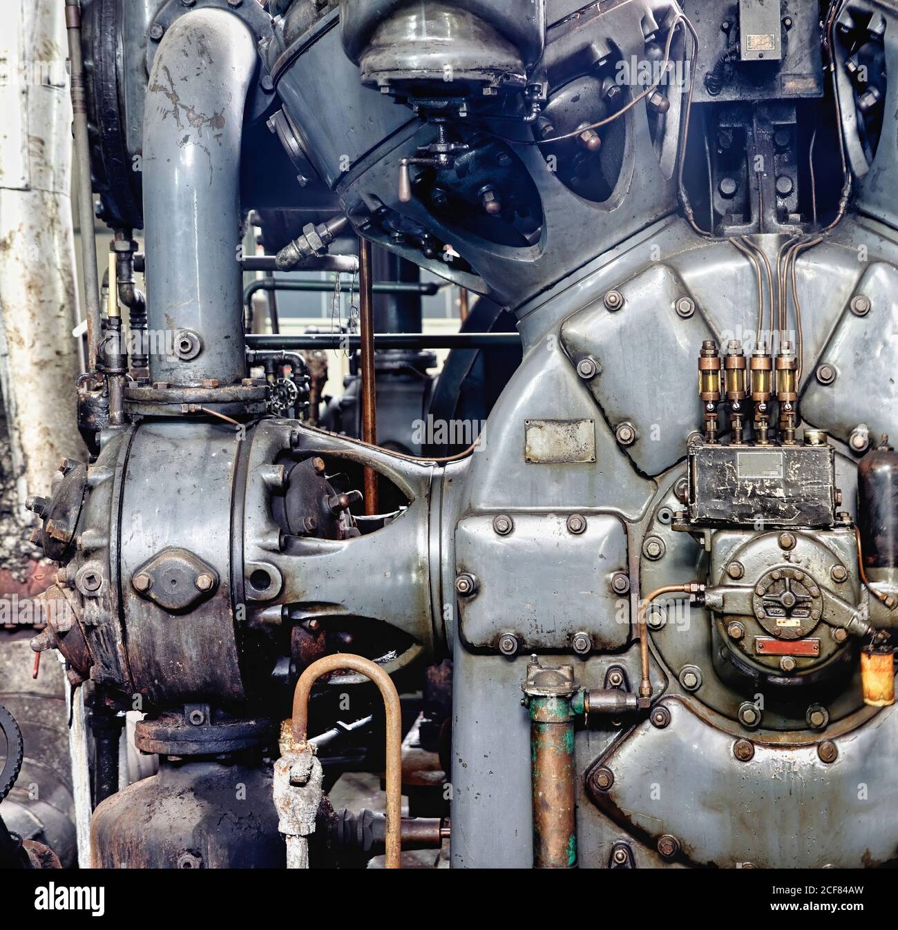 Vecchia apparecchiatura industriale inattiva grigia del generatore di potenza con vari fili tubi di acciaio e bulloni in deserta abbandonato miniera di carbone Foto Stock