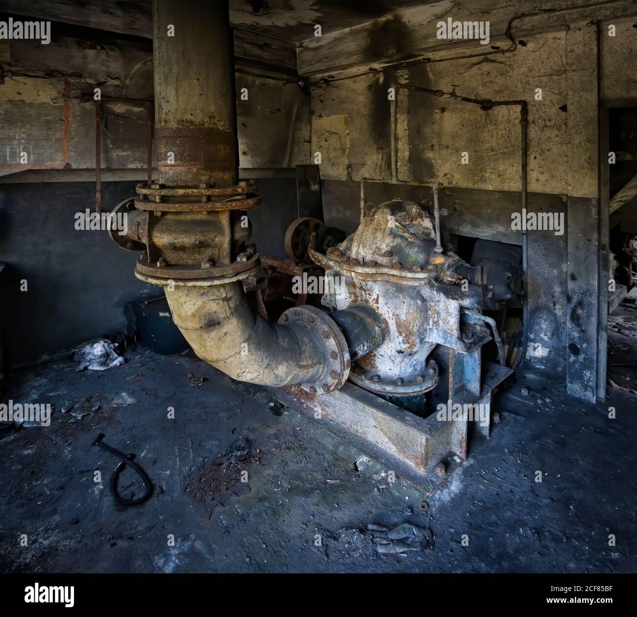 Costruzione in metallo con tubo installato all'interno di grugnoso edificio industriale abbandonato con pareti in shabby Foto Stock