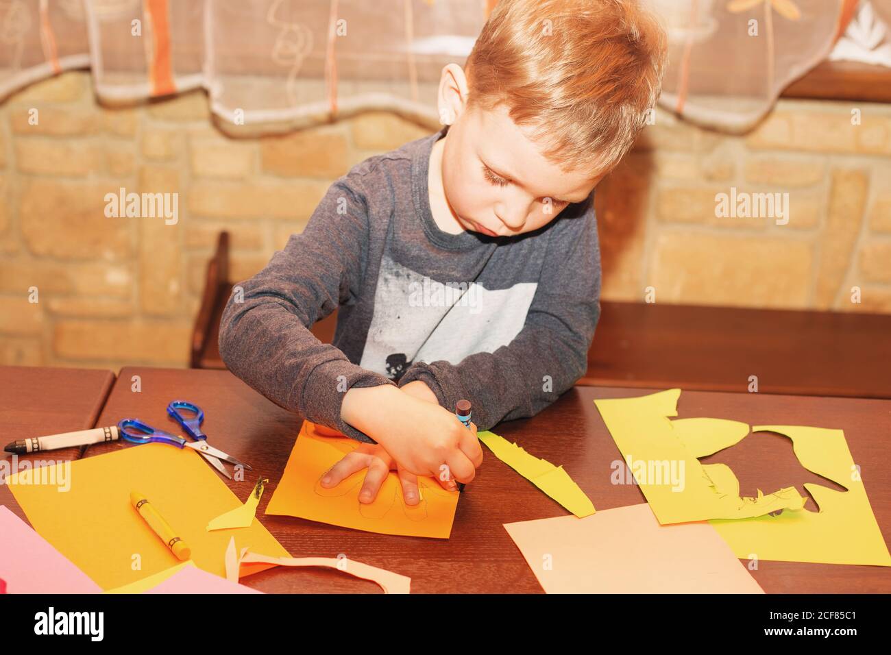 Il bambino traccia intorno ad una mano su carta con i pastelli. Un semplice disegno della mano di un bambino. Traccia palmo bambino. Tracciamento delle mani. Creatività dei bambini. Foto Stock