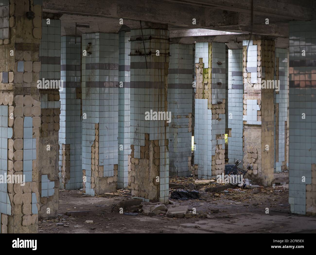 Muri in cemento e resti di scale in vecchio abbandonato industriale edificio con terreno disordinato Foto Stock