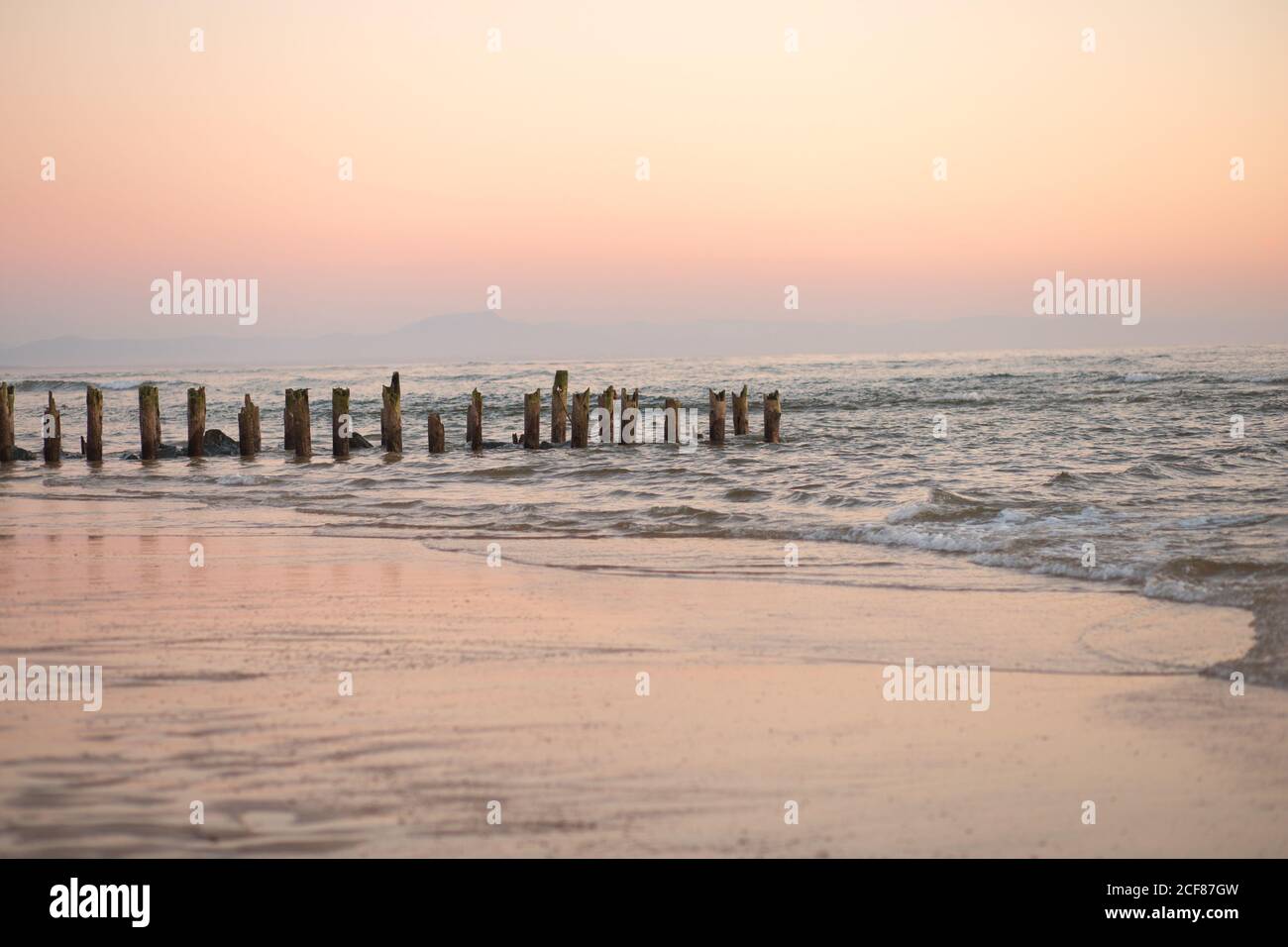 Vista pittoresca sulle acque tranquille del mare sullo sfondo orizzonte di colore rosa Foto Stock