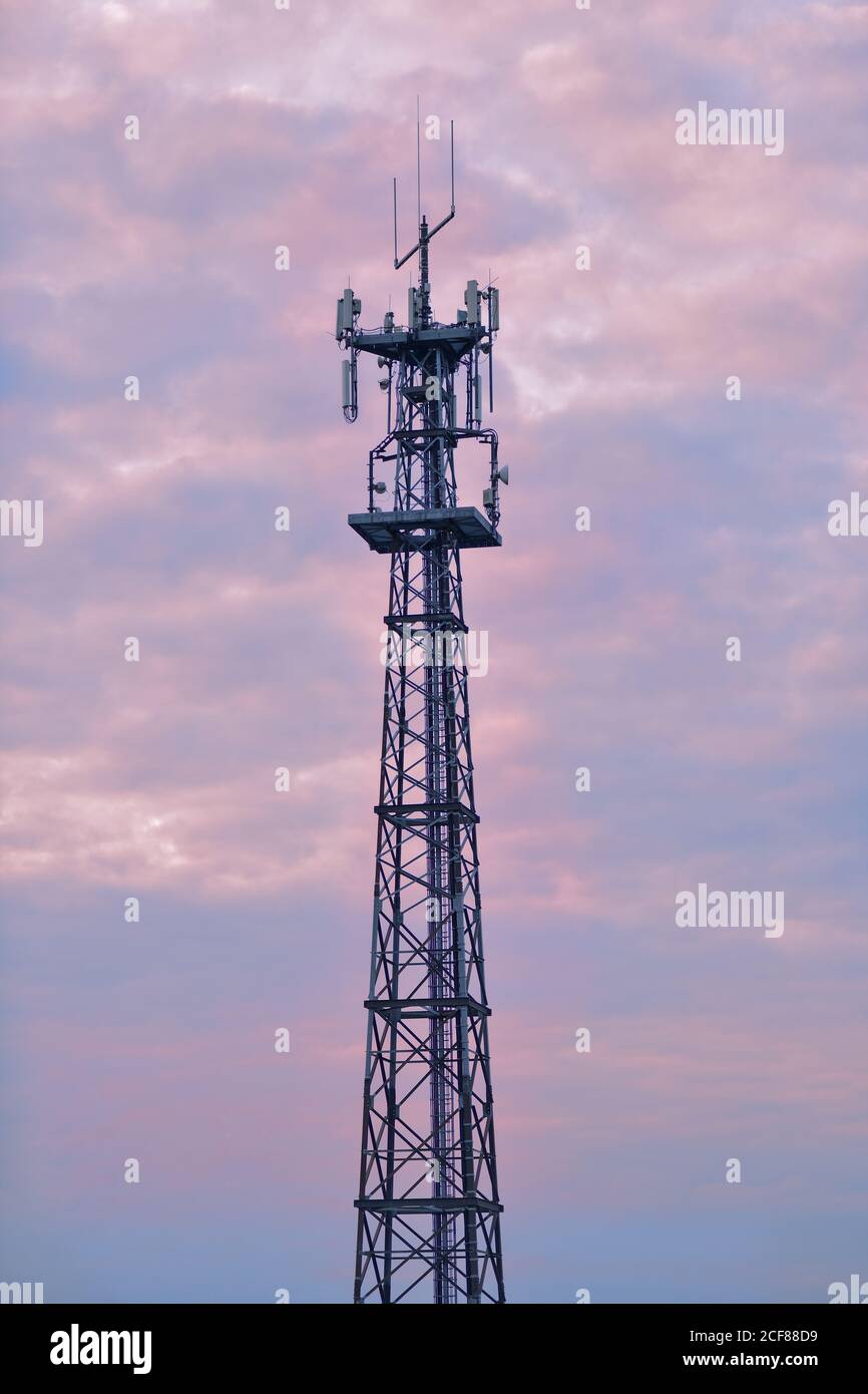 Torre del telefono cellulare contro un cielo color pastello durante il tramonto. Foto Stock