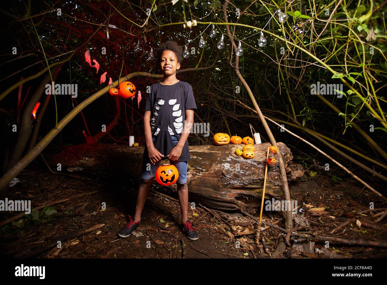 Ritratto di un ragazzo africano che guarda la macchina fotografica mentre visita il Festa di Halloween al buio all'aperto Foto Stock