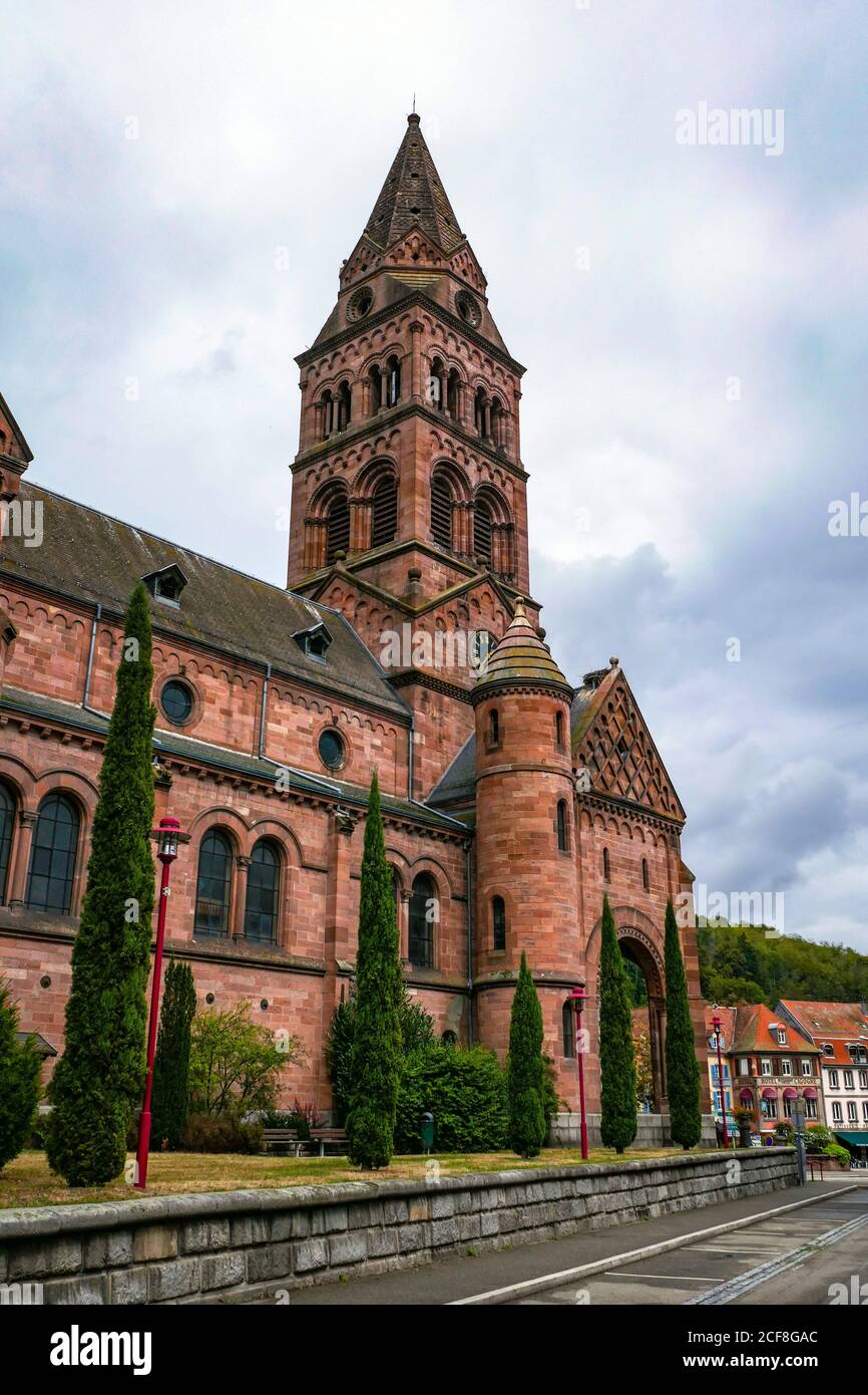 Grande chiesa in arenaria rossa con torre, ihe città vecchia di Munster, nei Vosgi montagne, Francia, Foto Stock