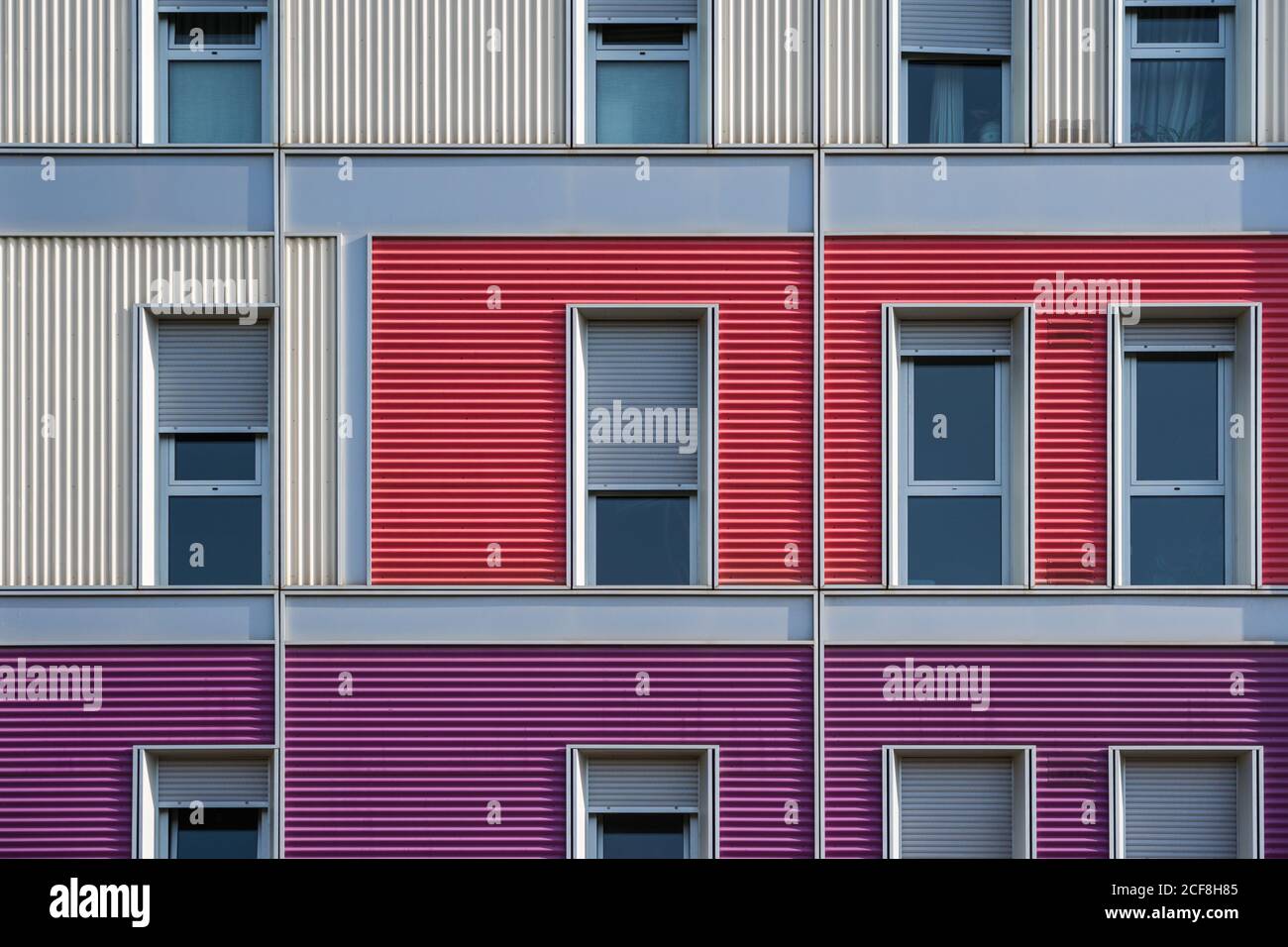 Esterno di una moderna casa urbana colorata con lunga metà aperta finestre strette Foto Stock