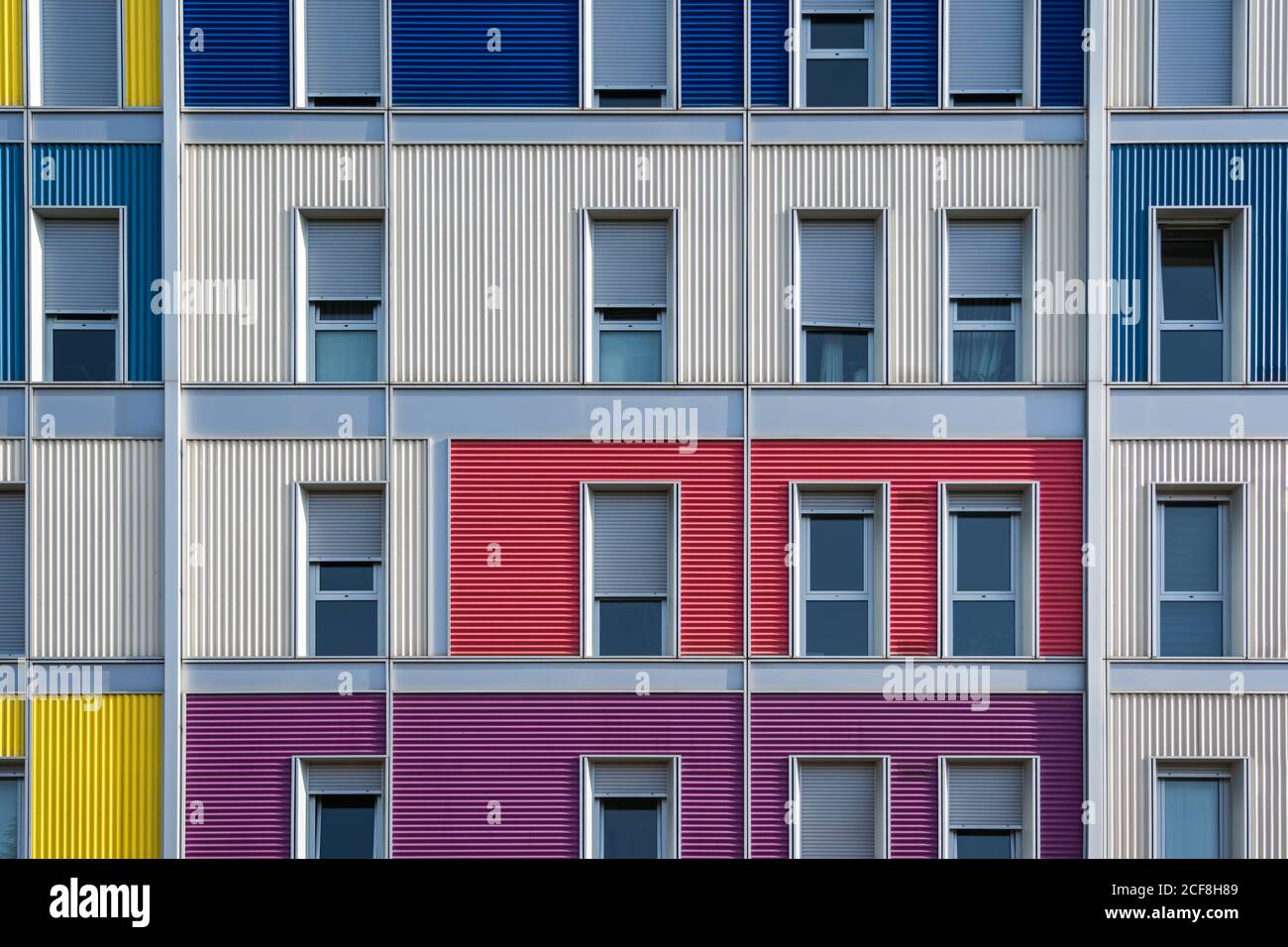 Esterno di una moderna casa urbana colorata con lunga metà aperta finestre strette Foto Stock