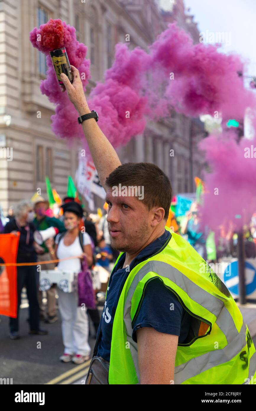 Un protestore tiene una bomba di fumo di colore rosa durante la dimostrazione della ribellione estinzione, Londra, 1 settembre 2020 Foto Stock