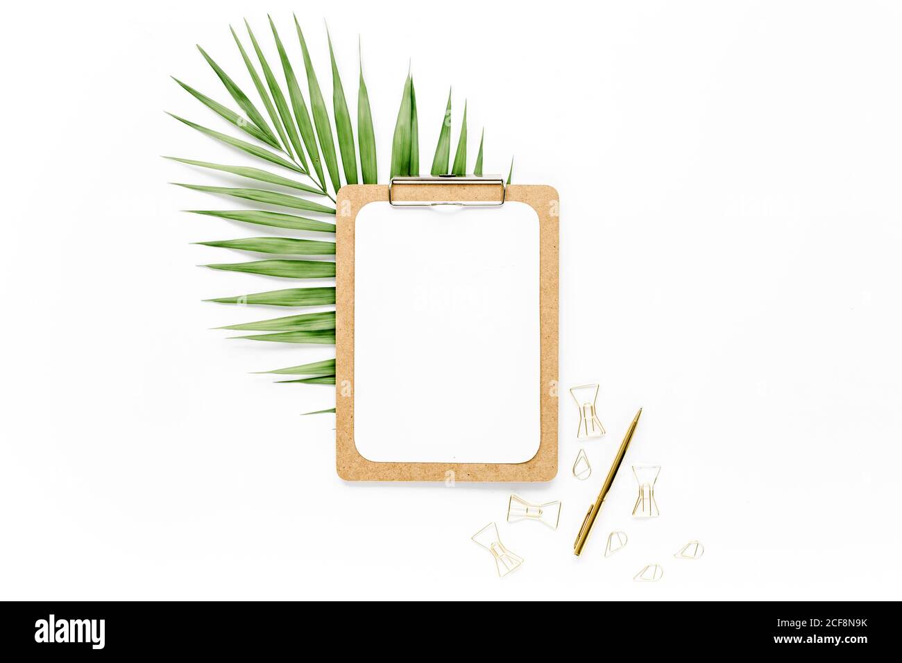 Home Office Workspace mockup con foglie tropicali Monstera, appunti, e accessori su sfondo bianco. Disposizione piatta, vista dall'alto Foto Stock