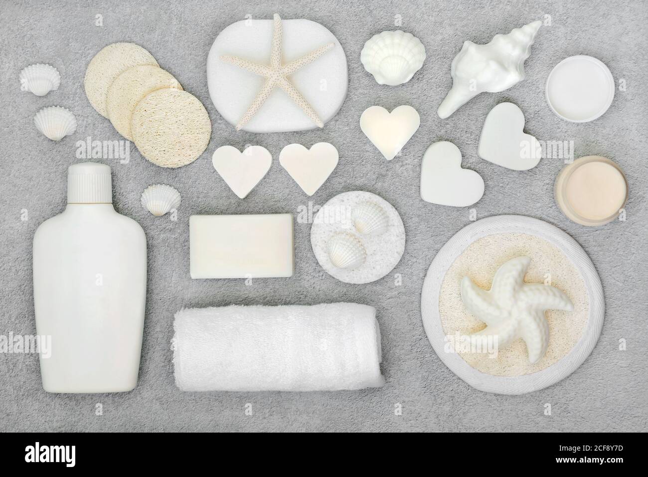 Prodotti naturali per il trattamento della bellezza biologica per la cura della pelle con saponi, crema idratante, spugne detergenti e scrub. Giacitura piatta su grigio chiazzato. Foto Stock