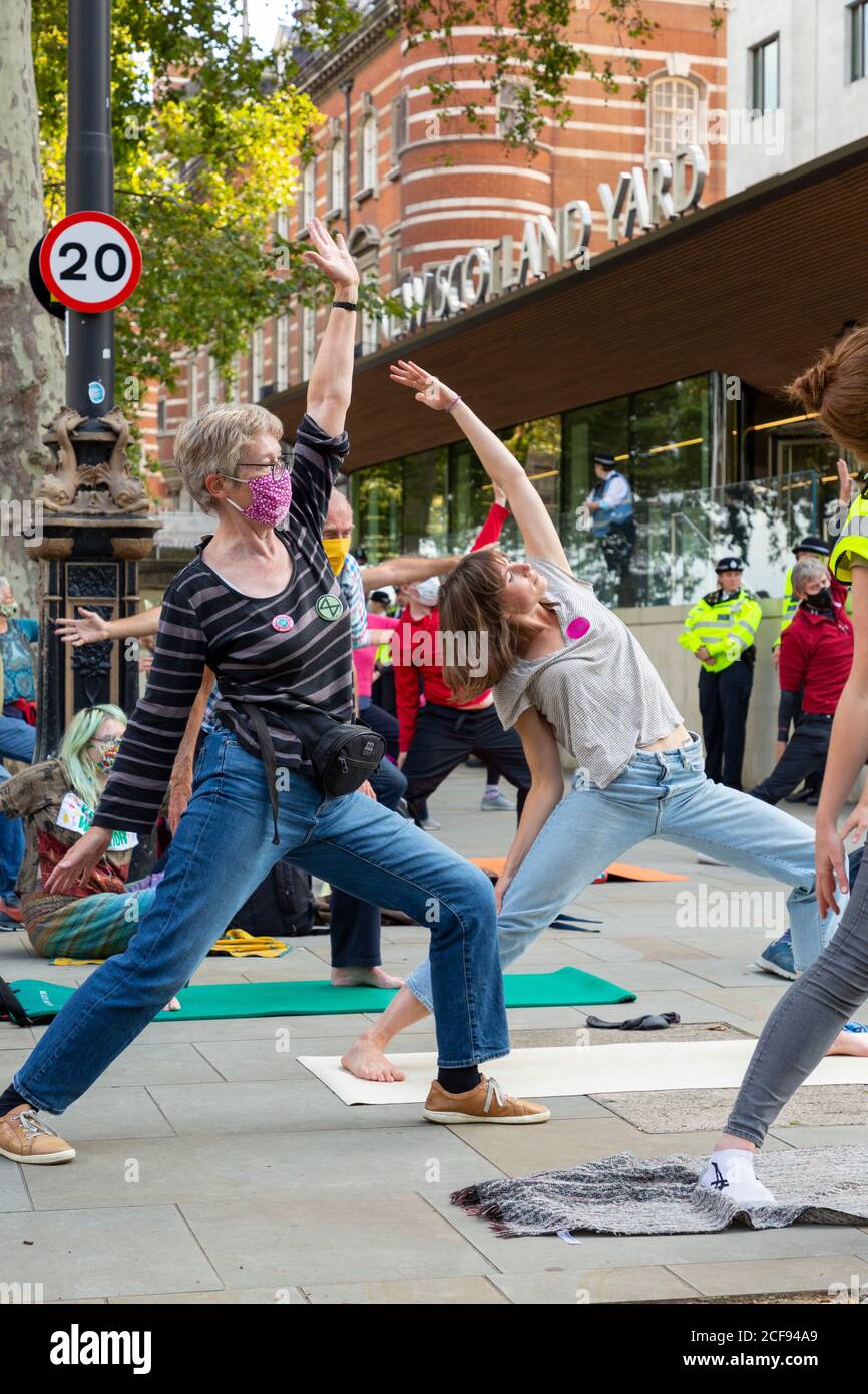 I manifestanti scioperano lo yoga fuori New Scotland Yard durante la manifestazione Extinction Rebellion, Westminster, Londra, 1 settembre 2020 Foto Stock