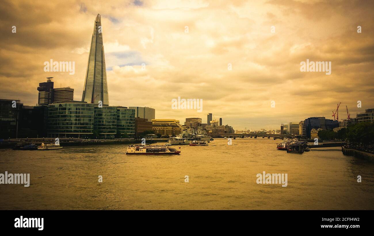 Shard e il Tamigi in una giornata intensa, catturando il trambusto della vita della città di Londra. Preso da Butlers Wharf. Foto Stock