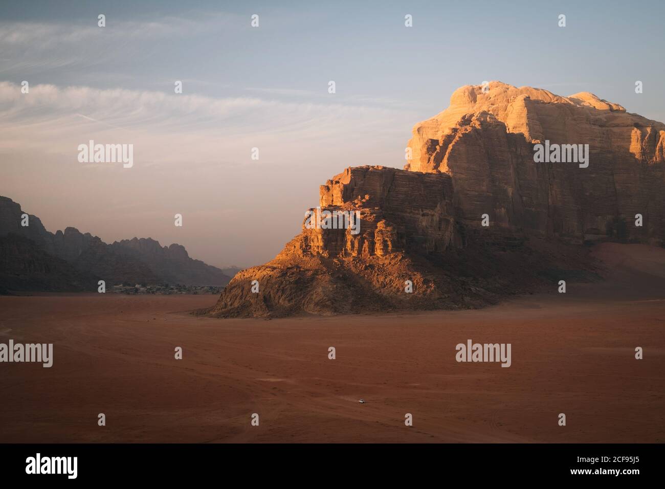 Una jeep nel mezzo del deserto gigante di Wadi Rum durante il tramonto Foto Stock
