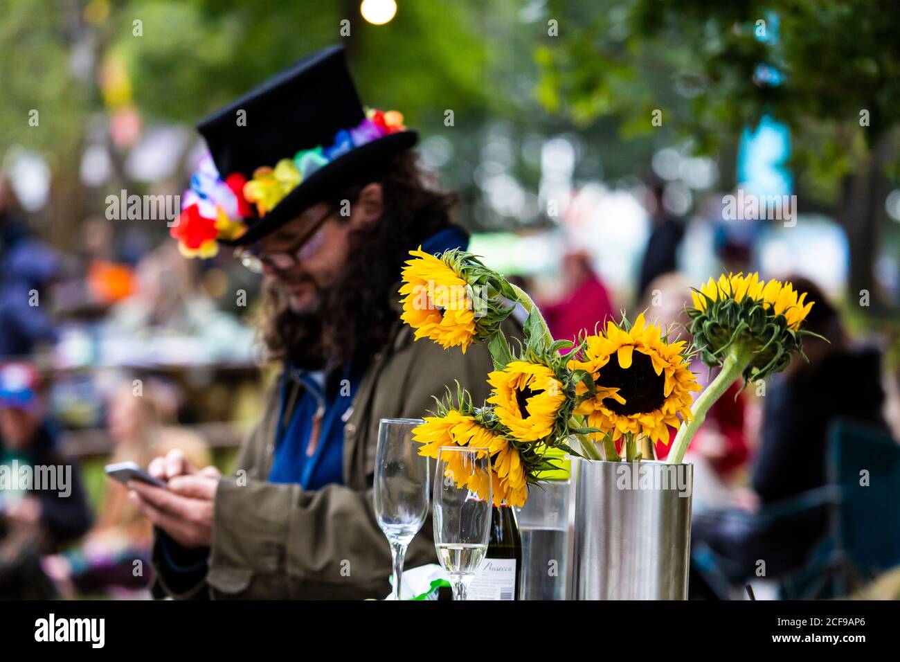 Uomo in un cappello con girasoli a We are Non è un festival socialmente distanziato evento a Pippingford Park - camping con un'atmosfera da festa Foto Stock