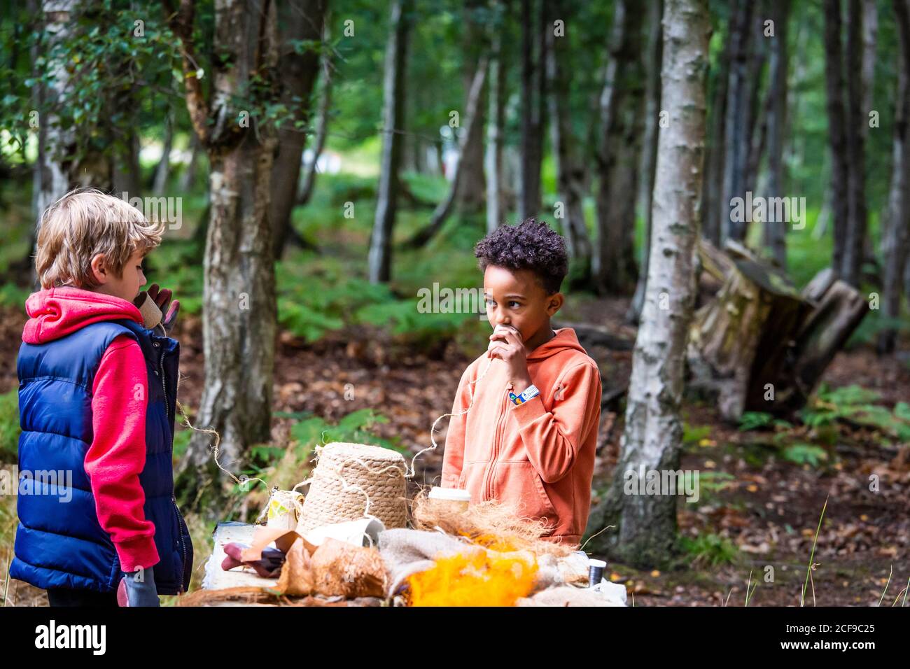 Ragazzi che parlano di telefono pungente al laboratorio creativo a noi Non sono un festival socialmente distanziato evento a Pippingford Park - campeggio con atmosfera da festa Foto Stock
