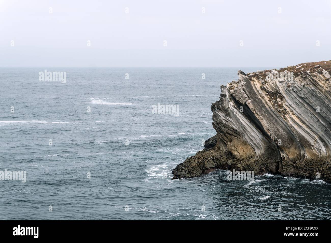 Formazioni rocciose nell'isola di Baleal sulla costa atlantica in una giornata di nebbia. Peniche, Portogallo Foto Stock