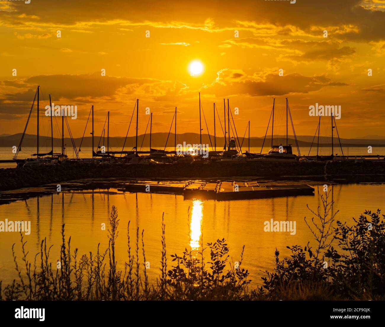 Il sole d'oro che si riflette sul lago Champlain a Burlington, Vermont, sul porto turistico con barche a vela Foto Stock