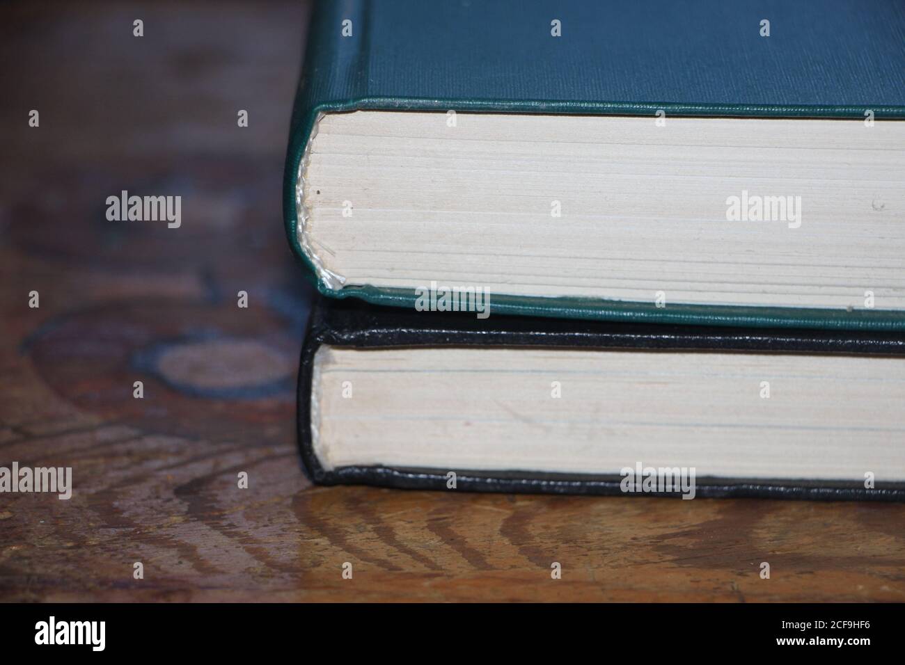 Due libri mettono il togeter sul vecchio tavolo di legno. Concetto di conoscenza e istruzione Foto Stock
