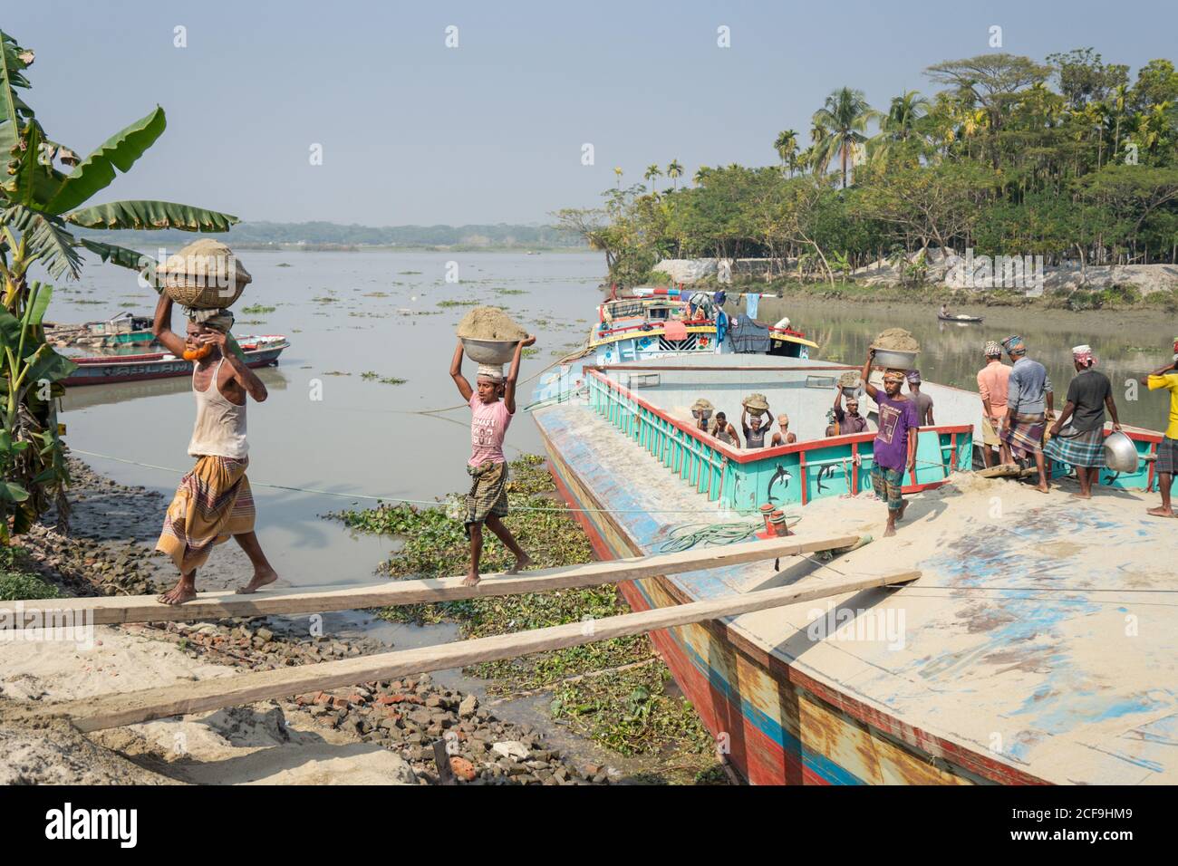 Etnie locali che scaricano pesce dalla barca dopo aver pescato Barisal in Bangladesh Foto Stock