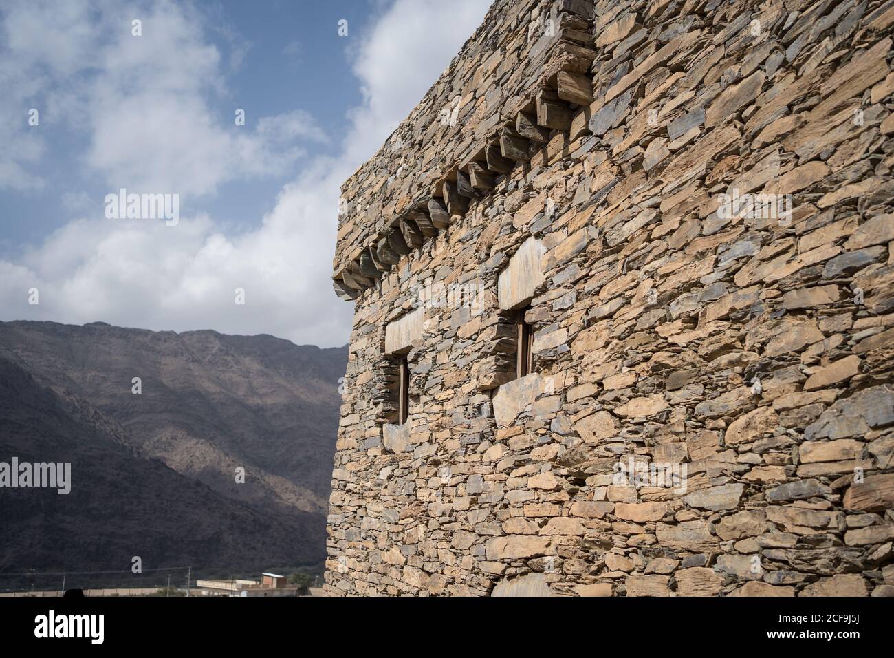 Esterno dell'antica parete in pietra di un edificio storico in marmo Villaggio in al Bahah sullo sfondo di terreno roccioso e. cielo nuvoloso in estate in Arabia Saudita Foto Stock