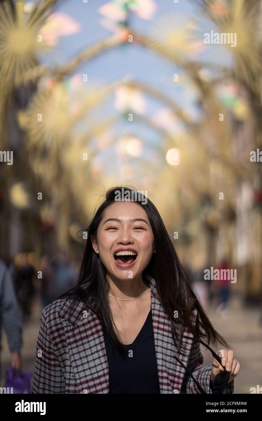 Felice giovane donna etnica in strada in centro Foto Stock