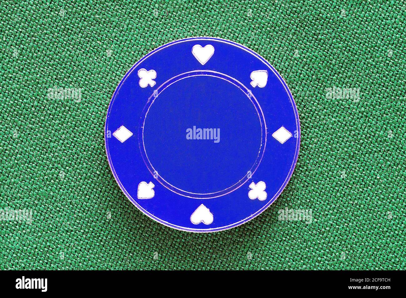 Chip casinò blu con tute da gioco sul tavolo tessile verde per il poker. Trama sfondo gioco d'azzardo Foto Stock