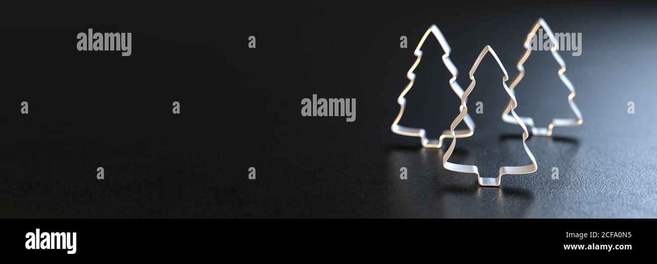 Tre frese per biscotti dell'albero di Natale in piedi su un piatto nero. Dimensione banner Web. Spazio di copia Foto Stock