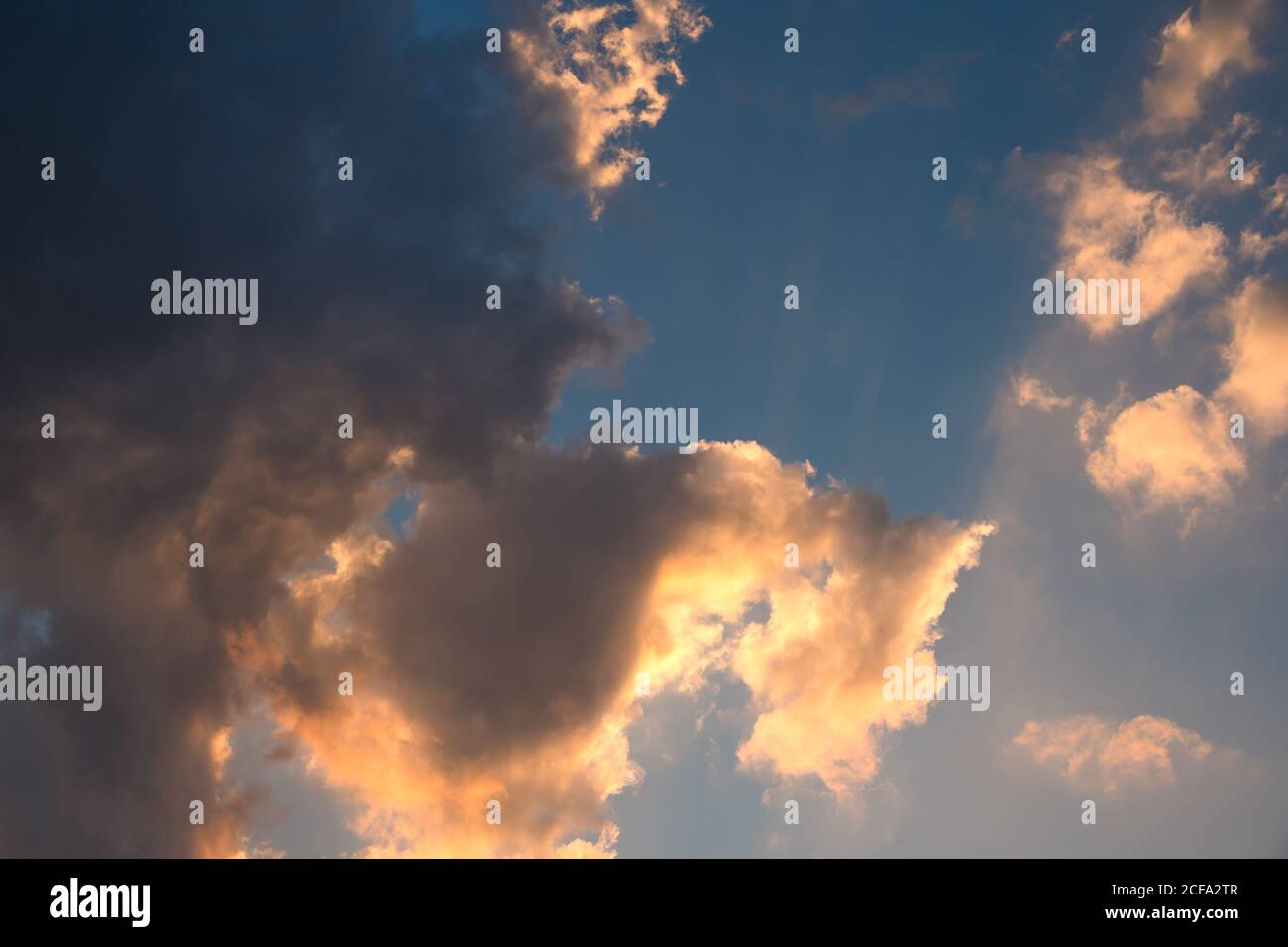Drammatico cielo sovrastato con le sfumature del sole, nei colori giallo e blu, immagine di sfondo. Foto Stock