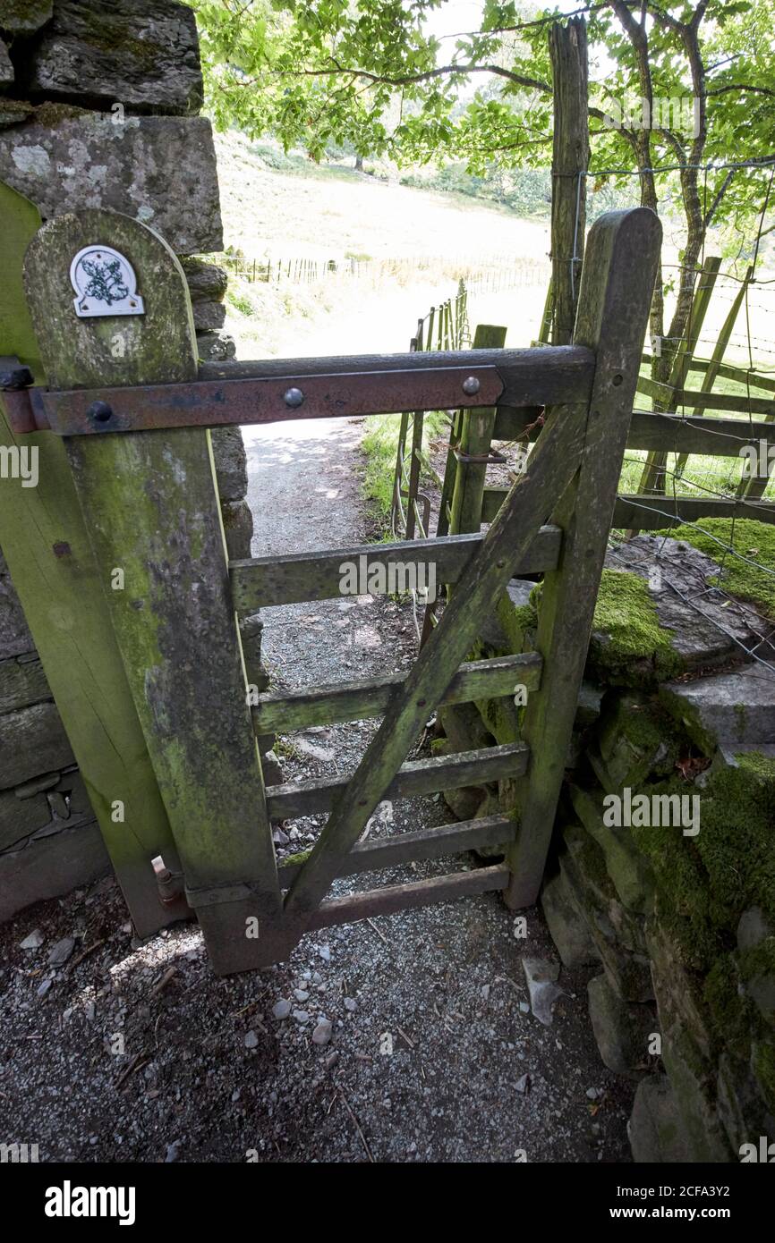 cancello bacia in legno basculante cancello d'ingresso per pedoni a nazionale trust footpath loughrigg lake district national park cumbria inghilterra regno unito Foto Stock