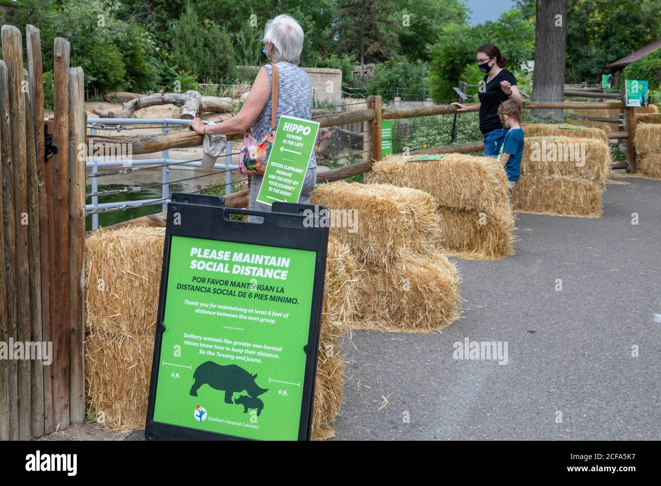 Denver, Colorado - i visitatori dello zoo di Denver durante la pandemia del coronavirus mantengono la distanza sociale, guidati da balle di paglia, mentre si osserva il Foto Stock