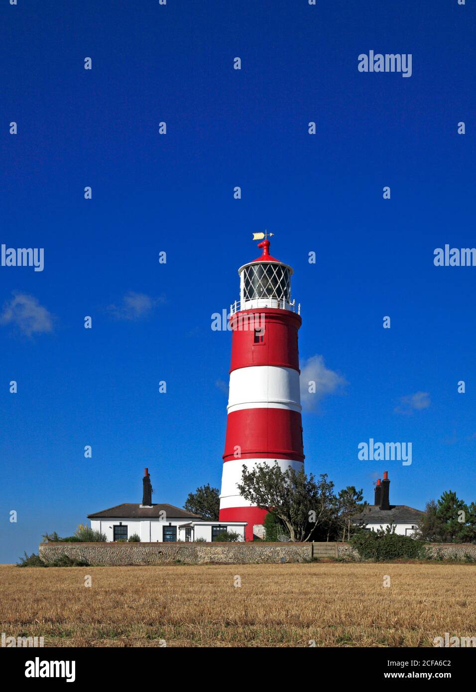 Una vista del faro gestito in modo indipendente con vecchi cottage custodi sulla costa nord del Norfolk a Happisburgh, Norfolk, Inghilterra, Regno Unito. Foto Stock