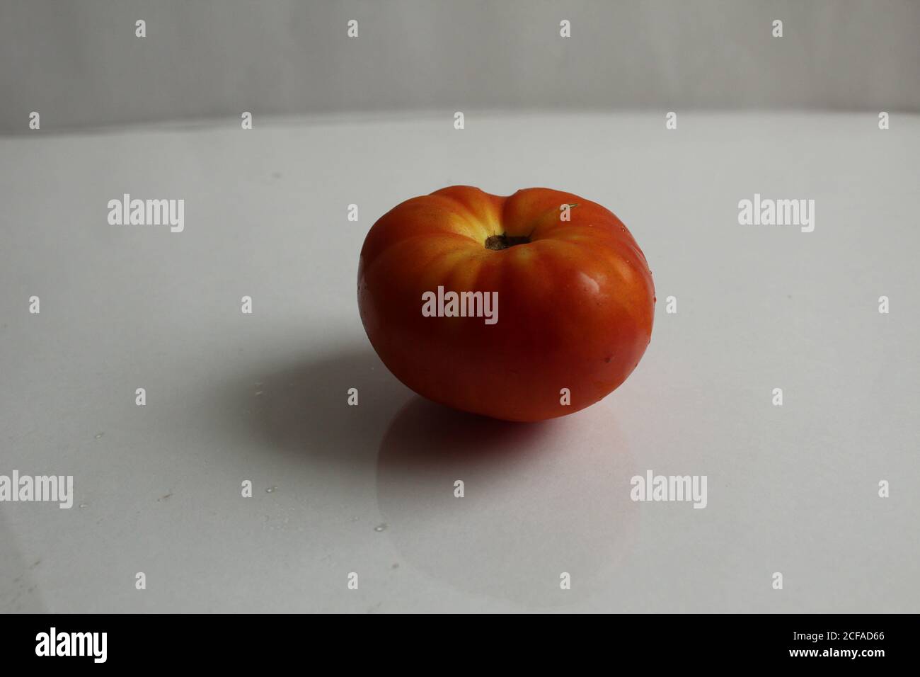 uno o più dei tre pomodori rosso-arancio su a. sfondo bianco con spazio per la copia Foto Stock