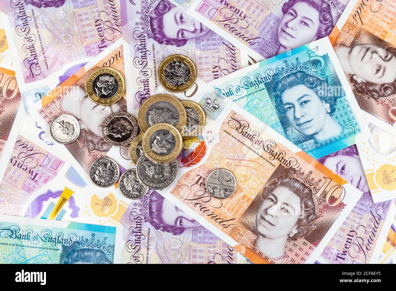 Banconote e monete in polimero da sterlina inglese nuove sparse Foto Stock