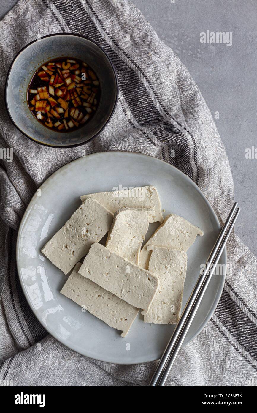 Delizioso piatto con tofu fritto in salsa di soia con verde cipolla Foto Stock