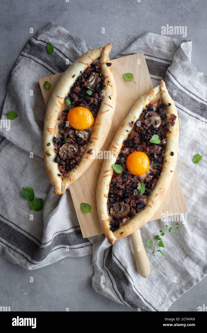 Fresco appetitoso kachapuri su stand in legno sulla biancheria a tavola Foto Stock