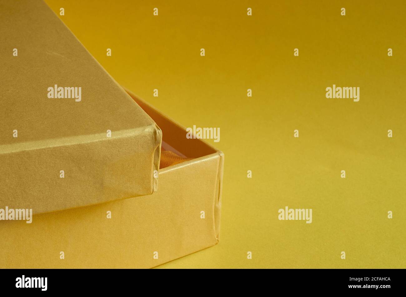 Bordo di una scatola di cartone gialla su sfondo giallo Foto Stock