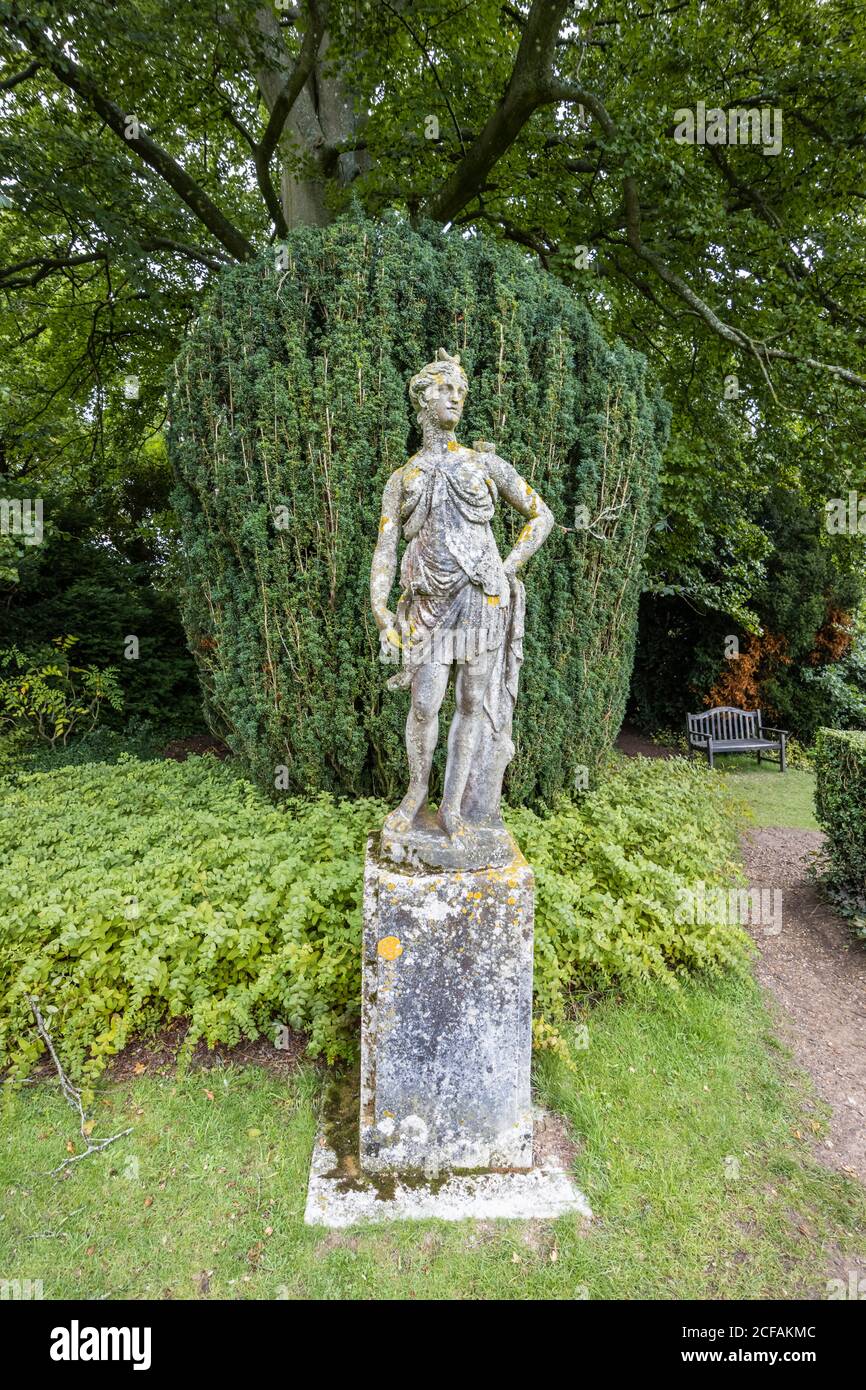 Statua in arrugginito di lichene della dea romana Diana (Artemis) su una base nei terreni di Hinton Ampner, Bramdean, Alresford, Hampshire, Inghilterra meridionale Foto Stock