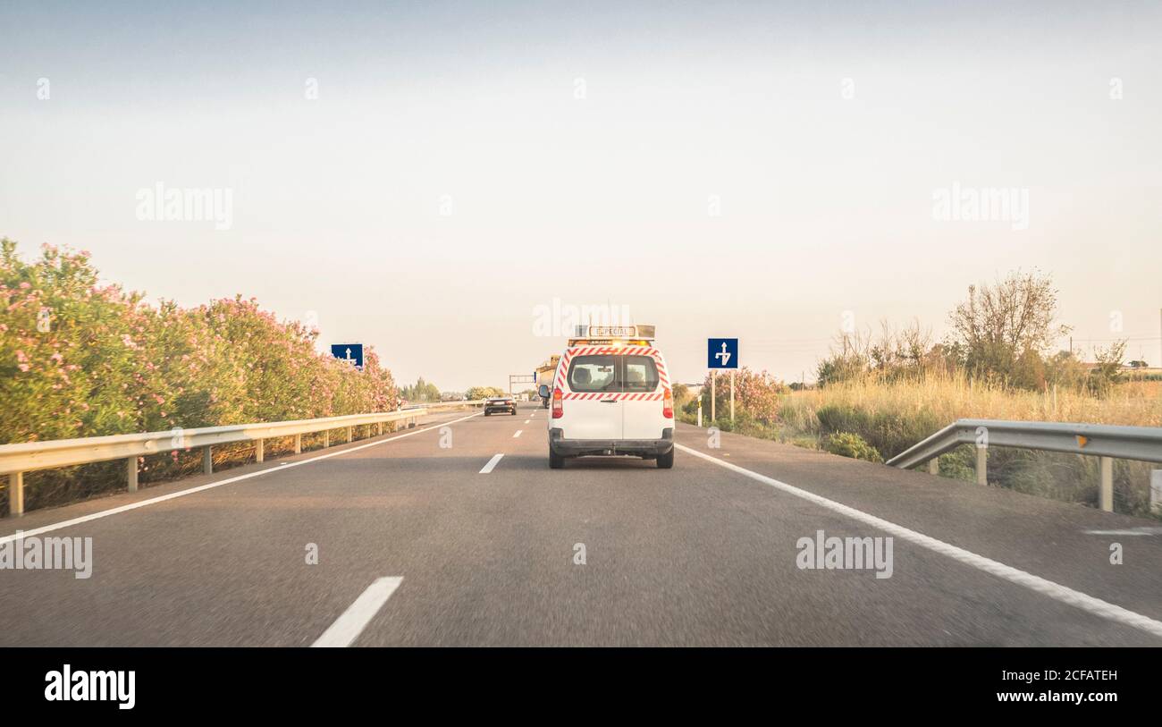 Vettura pilota o Escort dietro un autocarro con carico sovradimensionato. Vista dall'interno della vettura Foto Stock