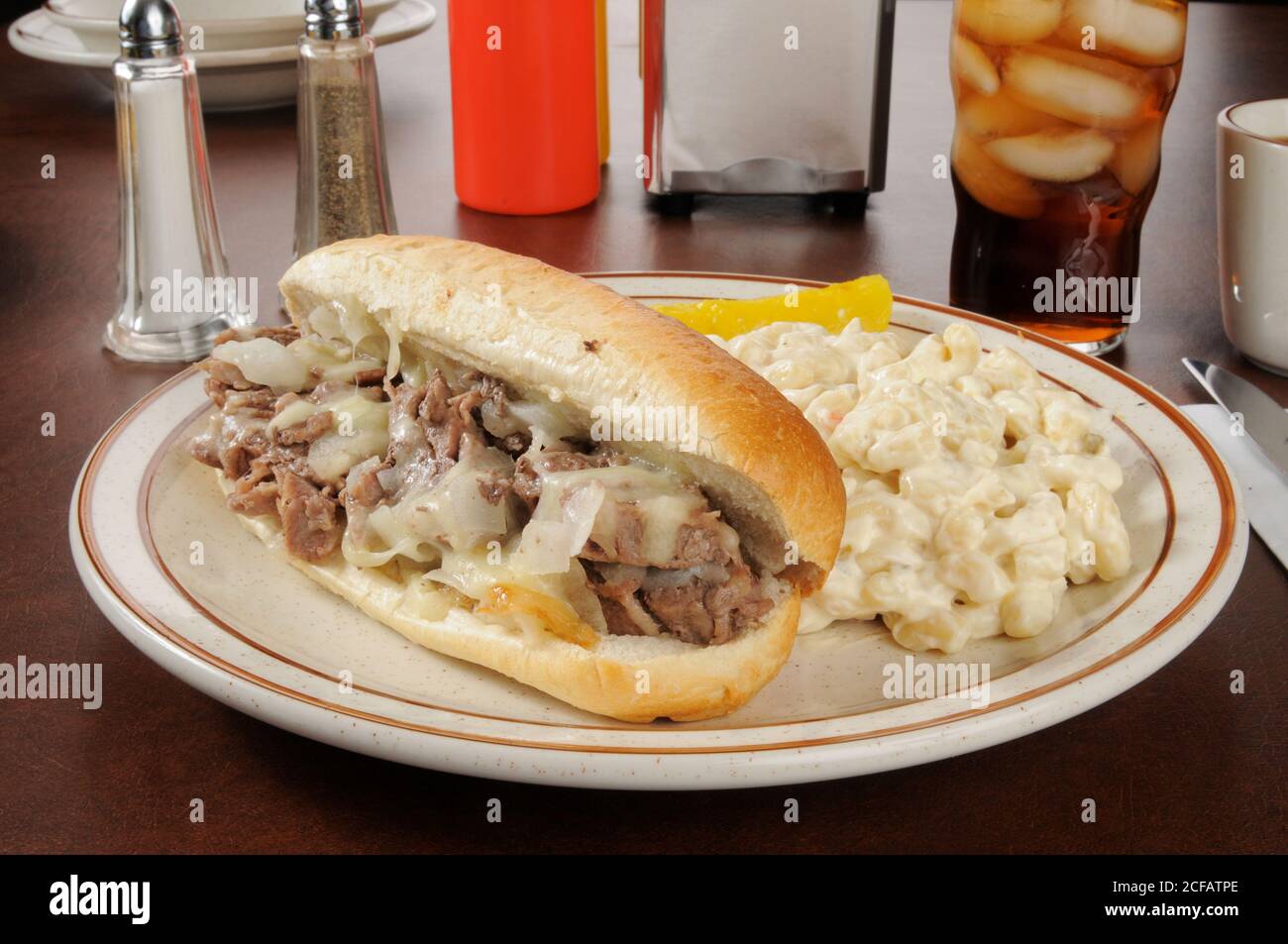 Un sandwich di bistecca al formaggio Philly con insalata di maccheroni Foto Stock