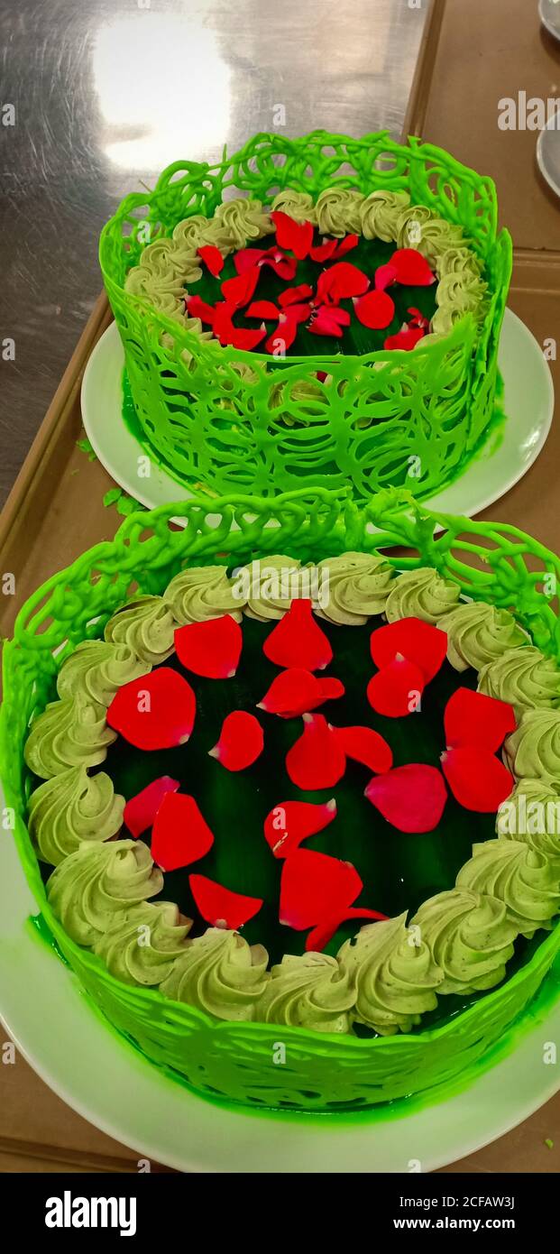 torta di tè verde guarnita con rose rosse Foto Stock