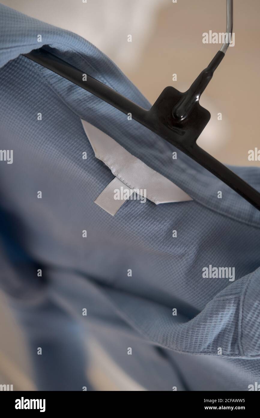 Etichetta di abbigliamento su tessuto azzurro. Marca di moda mock up, closeup, vista dall'alto Foto Stock