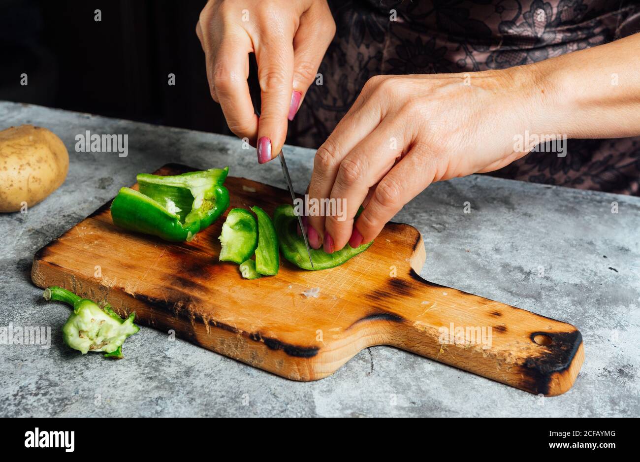 casalinga anonima che trita pepe verde fresco su tagliere di legno durante  la preparazione degli ingredienti per una cena nutriente Foto stock - Alamy